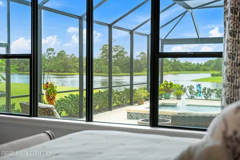 a living room with furniture a ceiling fan and a large window