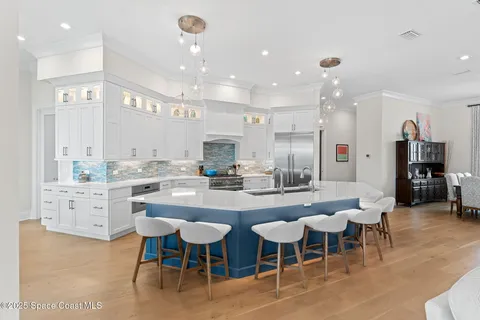 a living room with furniture a chandelier and a large window