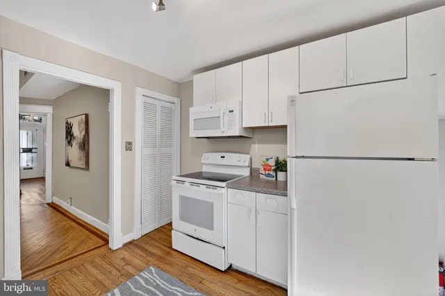 a kitchen with white cabinets and white appliances
