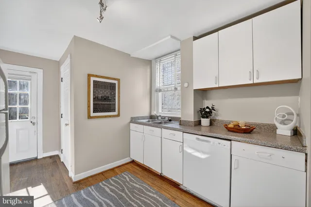 a kitchen with stainless steel appliances granite countertop a sink and cabinets with wooden floor