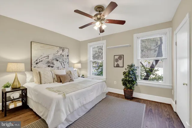 a bedroom with a large bed and a chandelier fan