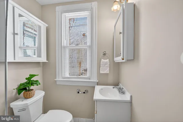 a bathroom with a sink toilet and a mirror