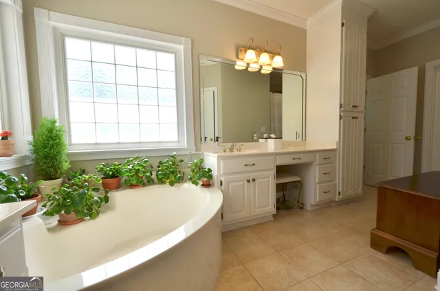 a spacious bathroom with a tub sink and mirror