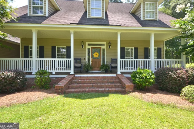 a view of a brick house with large garden and plants