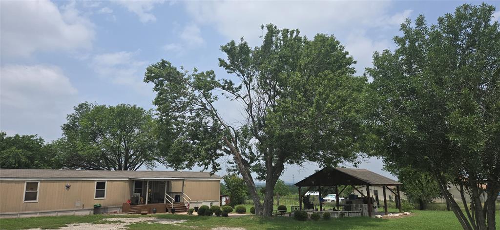 Back of house with a gazebo and a yard