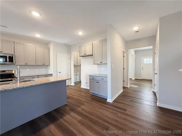 a large kitchen with cabinets wooden floor and stainless steel appliances