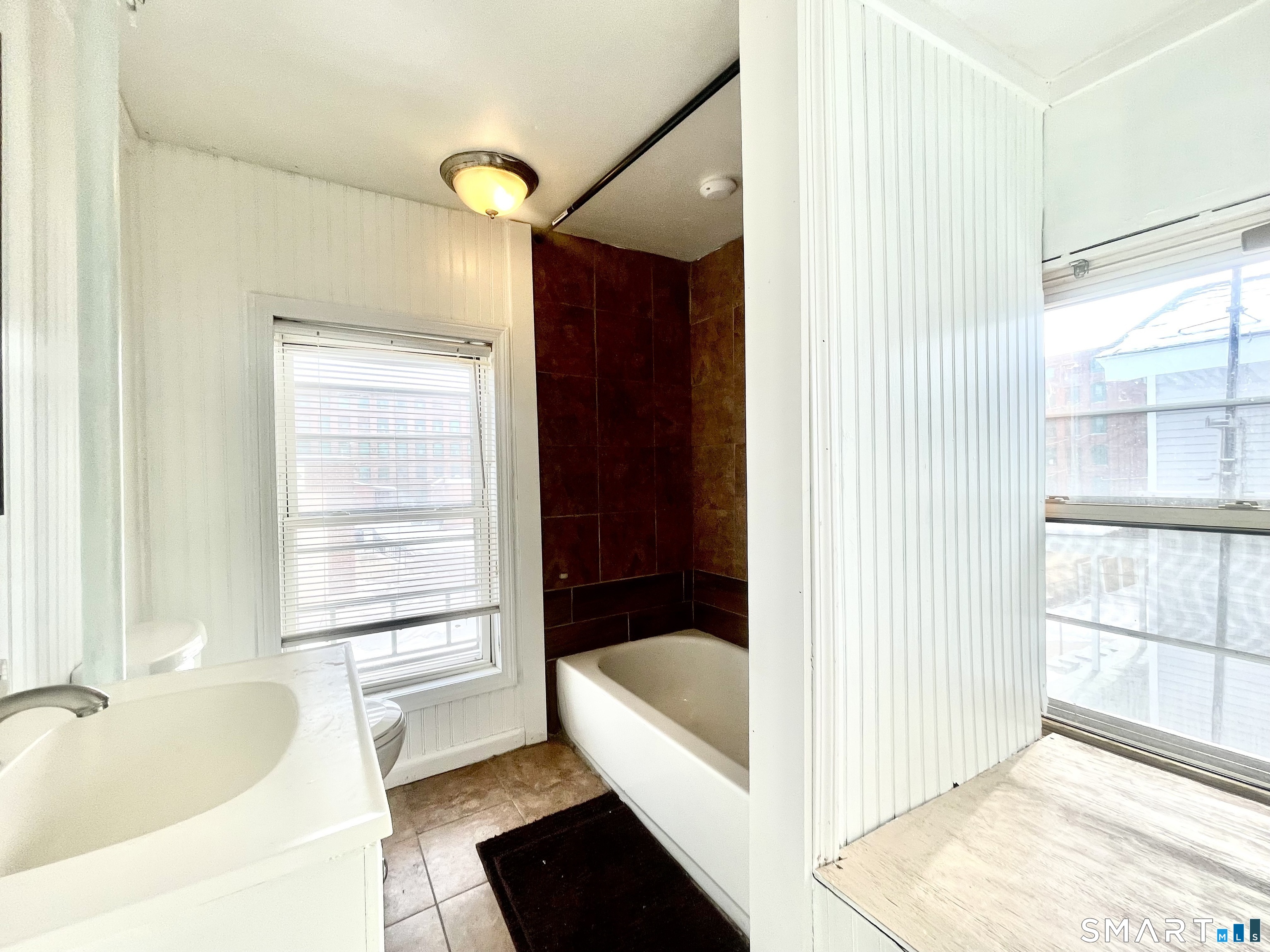 128 Franklin Street Waterbury, CT 06706 - Photo 22 of 25 a bathroom with a tub shower and window