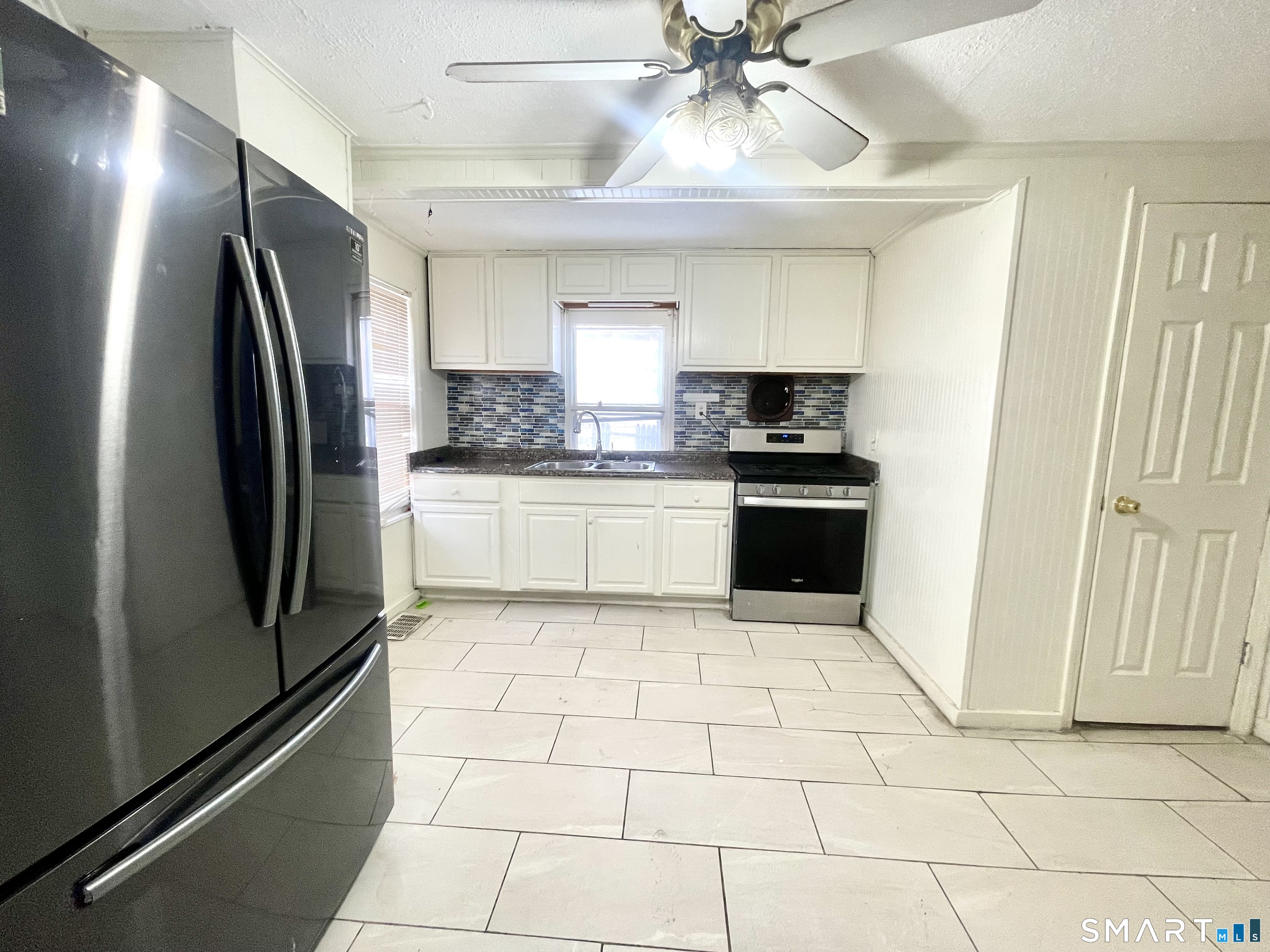 128 Franklin Street Waterbury, CT 06706 - Photo 5 of 25 a kitchen with stainless steel appliances granite countertop a refrigerator a sink a stove top oven and cabinets