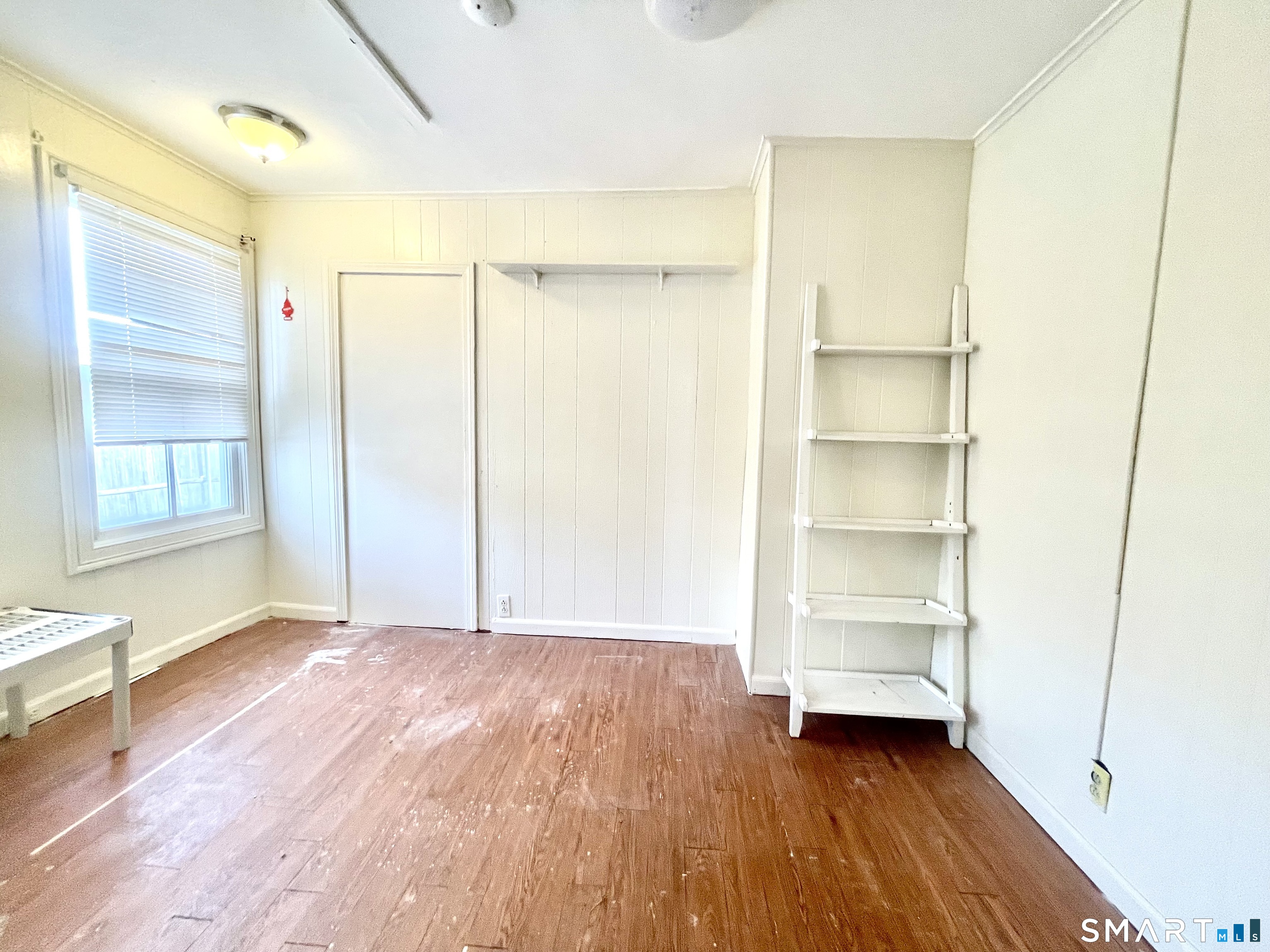 128 Franklin Street Waterbury, CT 06706 - Photo 8 of 25 a view of an empty room with a window and wooden floor