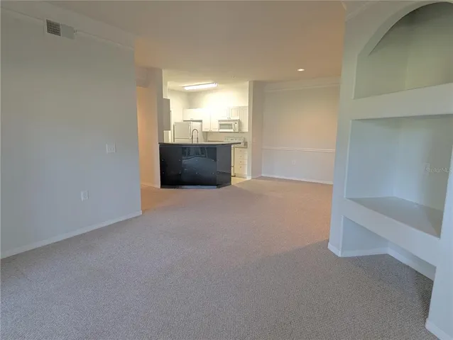 a view of a big room with wooden floor and windows