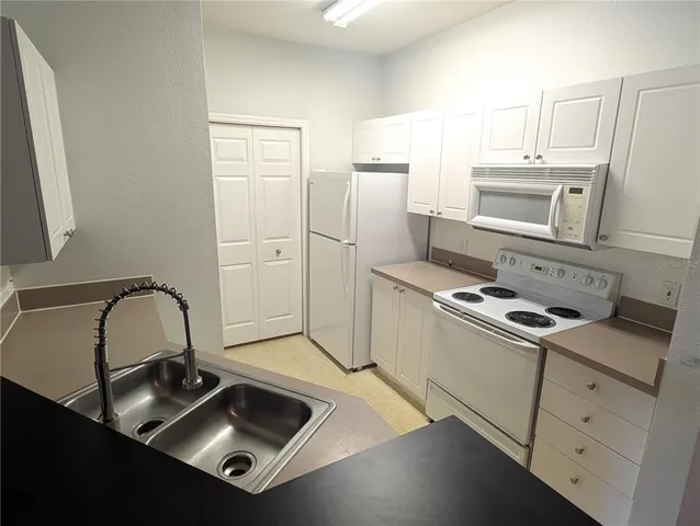 a kitchen with a sink stove and refrigerator