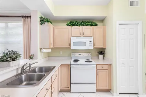 a kitchen that has a sink cabinets and window