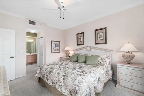 a bedroom with a large bed and a chandelier