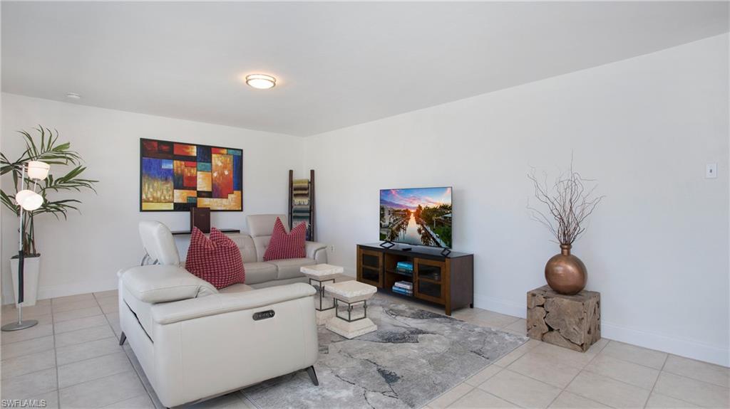 1560 Blue Point Avenue, Unit 3 Naples, FL 34102 - Photo 8 of 43 a living room with furniture and a flat screen tv
