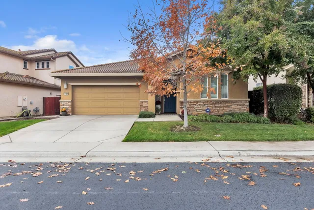 a front view of a house with a yard and a garage