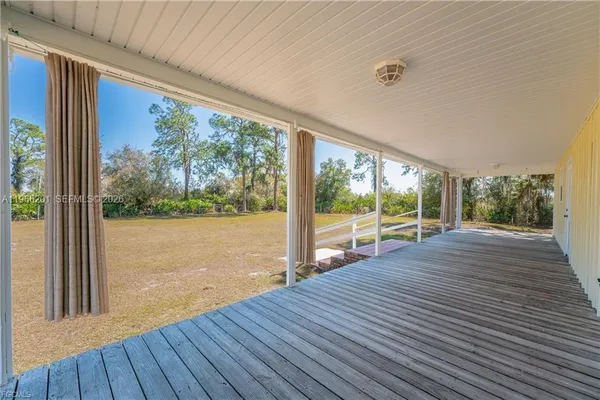 a view of a room with wooden floor and outdoor view