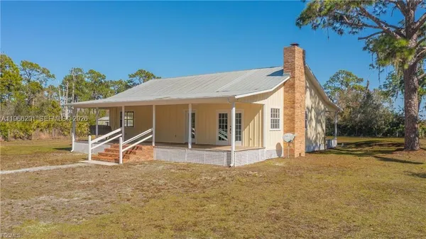 a view of a house with backyard and a tree