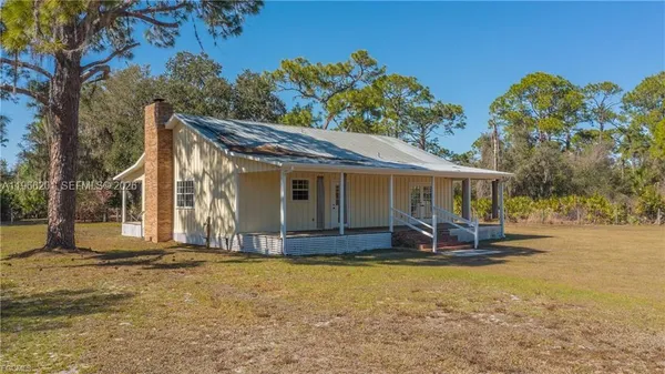 a view of a house with backyard and sitting area