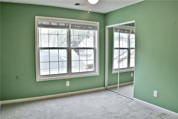 an empty room with a window and a chandelier