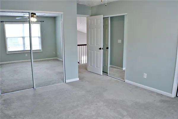 a view of an empty room with window and bathroom