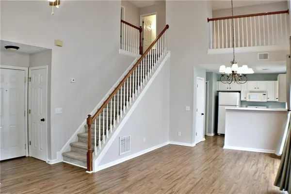 a view of a hallway with wooden floor and staircase