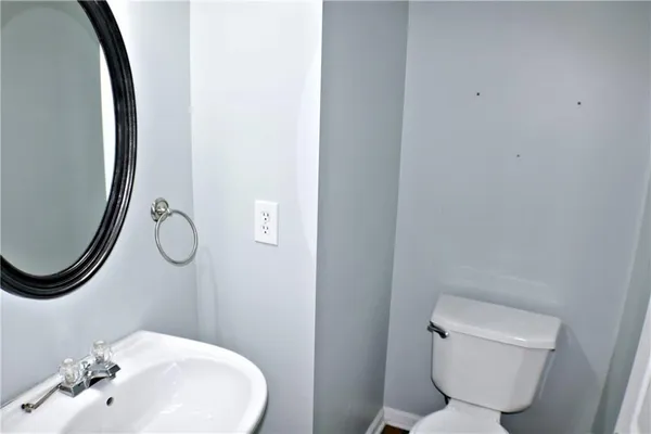 a bathroom with a toilet and a mirror