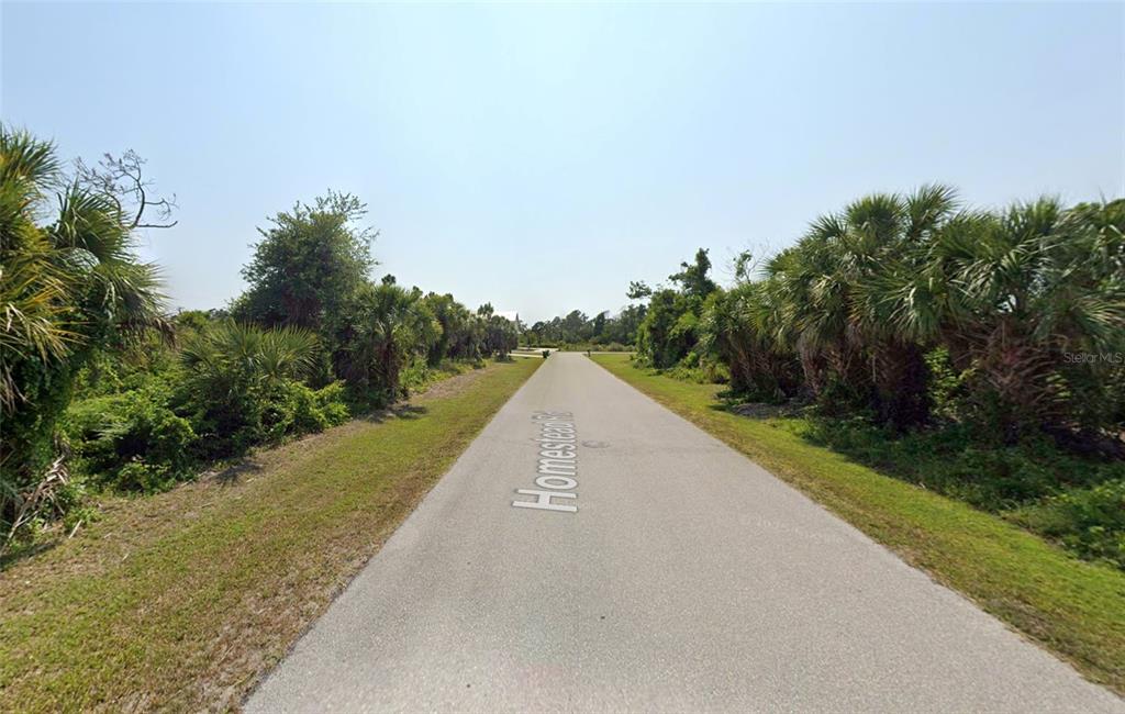 3435 Homestead Road Rotonda West, FL 33947 - Photo 5 of 6 a view of a street with a yard and lake view