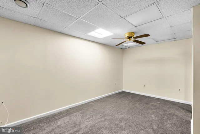 an empty room with a ceiling fan and wooden floor
