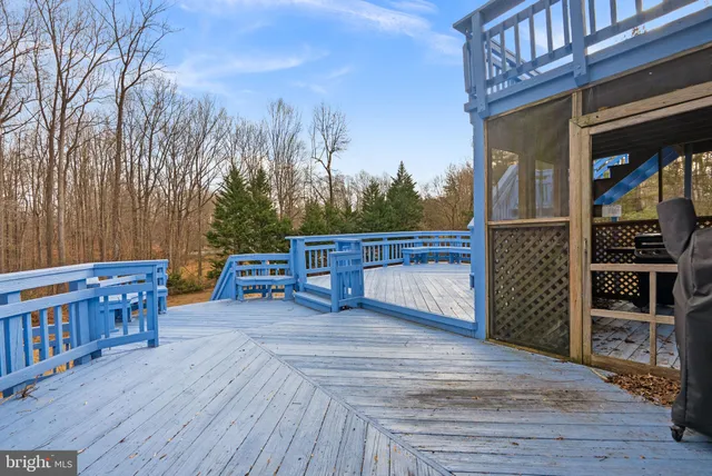 a view of a deck with table and chairs a barbeque with wooden floor and fence