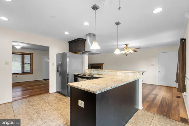 a kitchen with kitchen island a sink and a refrigerator