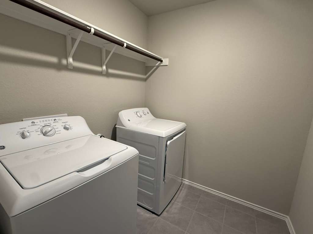 12212 Dillon Fls Drive Austin, TX 78747 - Photo 13 of 40 Laundry area with washing machine and dryer and tile patterned flooring