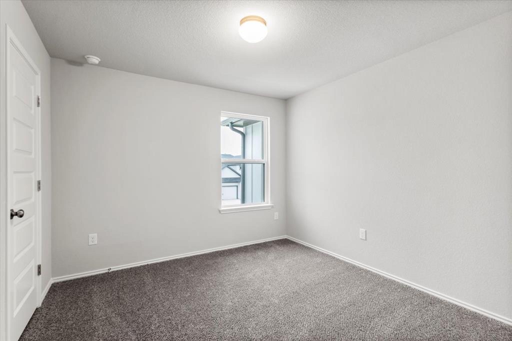 12212 Dillon Fls Drive Austin, TX 78747 - Photo 24 of 40 Unfurnished bedroom with a textured ceiling, carpet flooring, and a closet