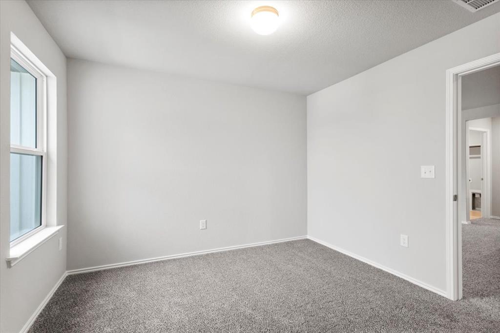 12212 Dillon Fls Drive Austin, TX 78747 - Photo 25 of 40 Carpeted spare room featuring a textured ceiling and baseboards