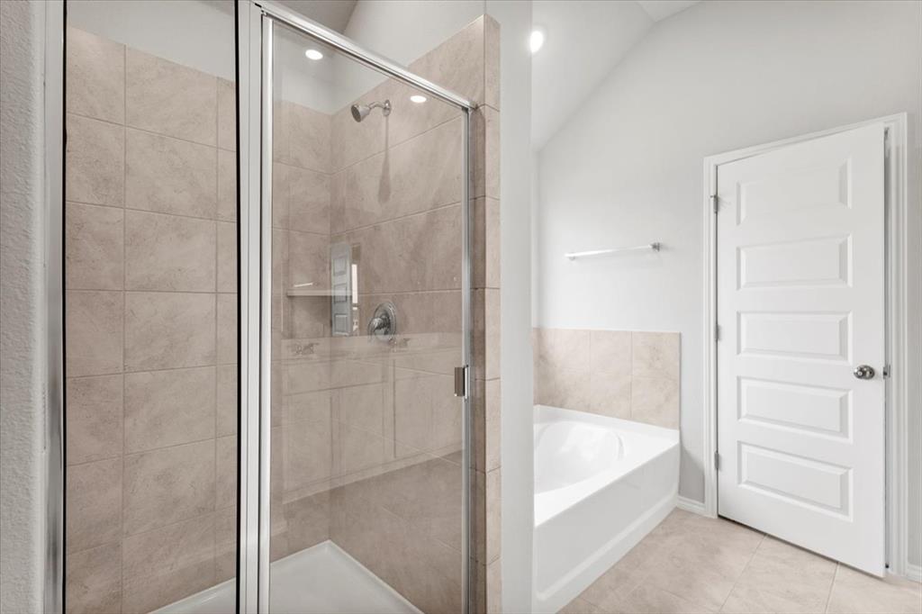 12212 Dillon Fls Drive Austin, TX 78747 - Photo 29 of 40 Bathroom featuring a bath, a stall shower, tile patterned floors, and vaulted ceiling