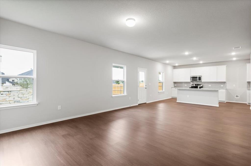 12212 Dillon Fls Drive Austin, TX 78747 - Photo 6 of 40 Unfurnished living room featuring dark wood-style floors and recessed lighting