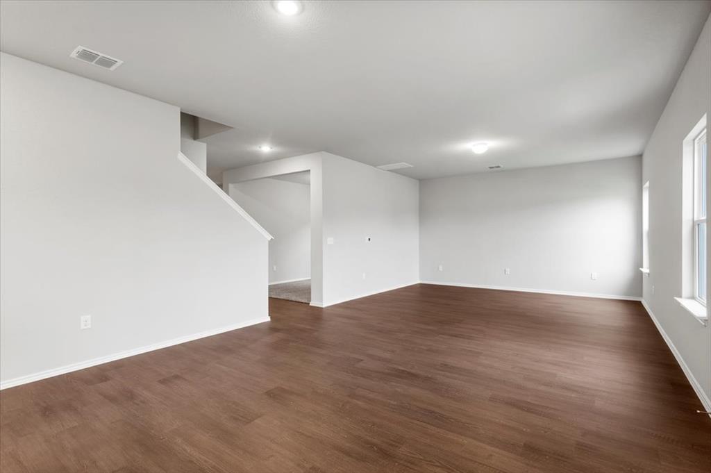 12212 Dillon Fls Drive Austin, TX 78747 - Photo 7 of 40 Empty room with dark wood finished floors and baseboards