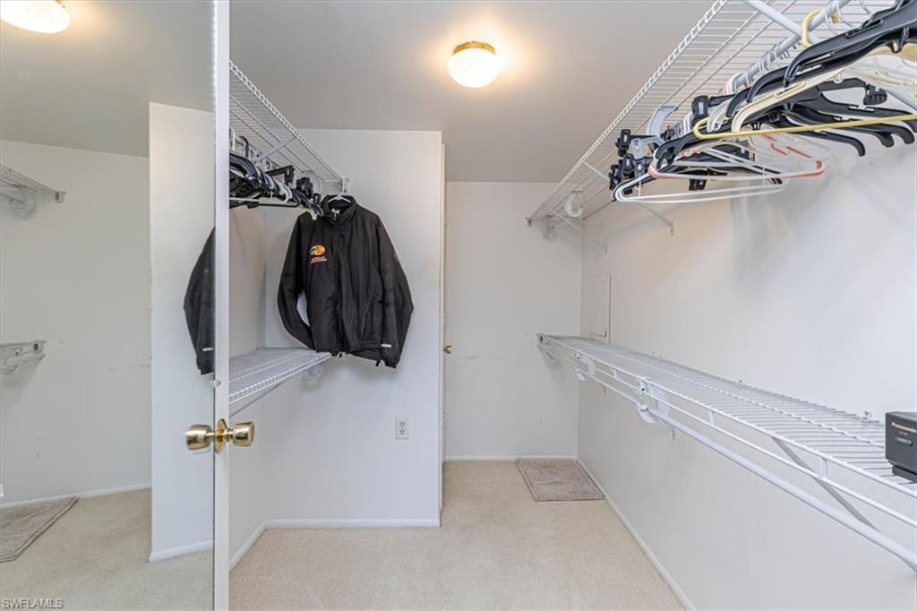 5483 Rattlesnake Hammock Road, Unit B201 Naples, FL 34113 - Photo 14 of 22 a view of walk in closet with clothes and shoes