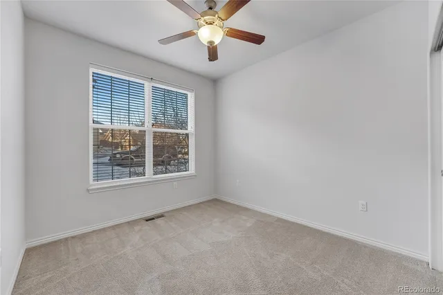 an empty room with a window and a fan