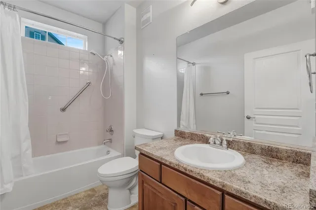 a bathroom with a granite countertop sink toilet and shower
