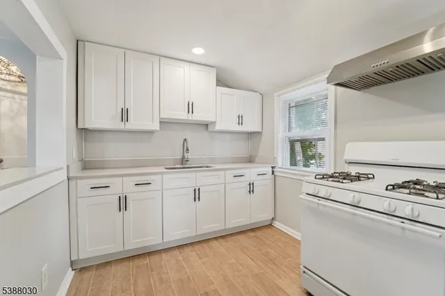 a kitchen with granite countertop cabinets stainless steel appliances and a wooden floor