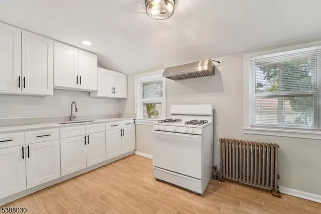a kitchen with granite countertop white cabinets and white appliances