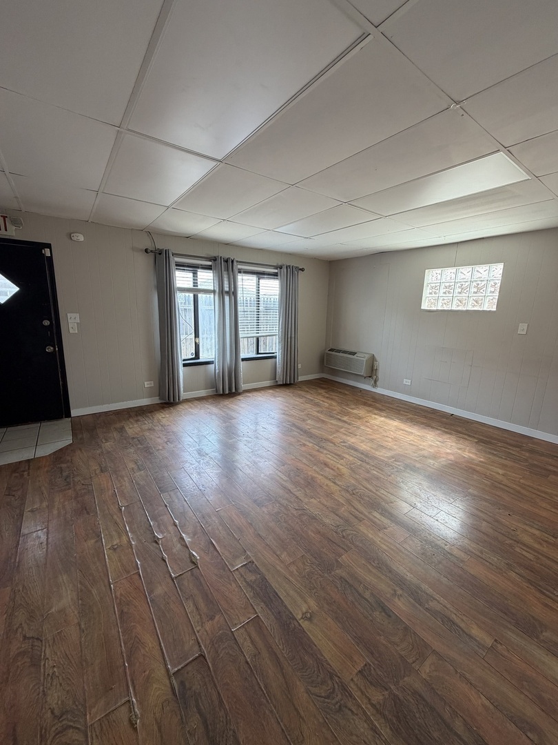 6551 West 63rd Street Chicago, IL 60638 - Photo 3 of 9 a view of an empty room with wooden floor and a window