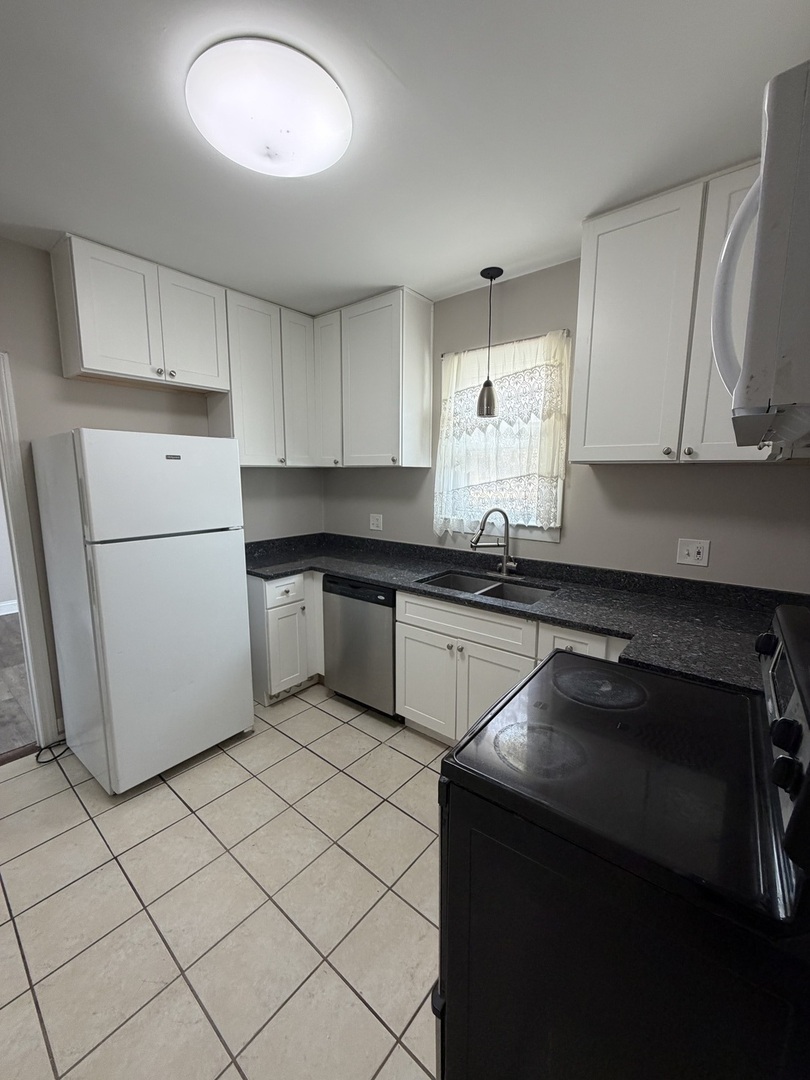 6551 West 63rd Street Chicago, IL 60638 - Photo 6 of 9 a kitchen with a sink a stove and cabinets