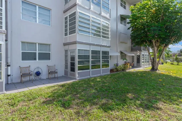 a view of a backyard with table and chairs and large trees