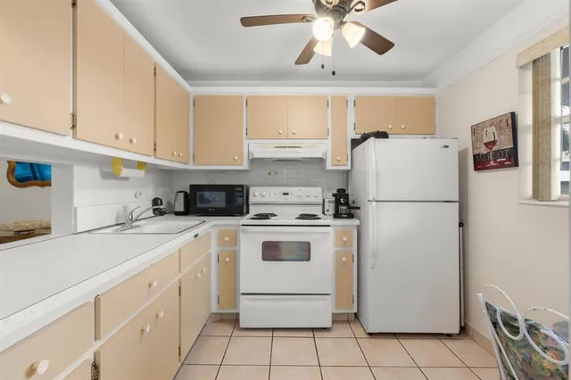 a kitchen with a refrigerator a stove a sink and cabinets