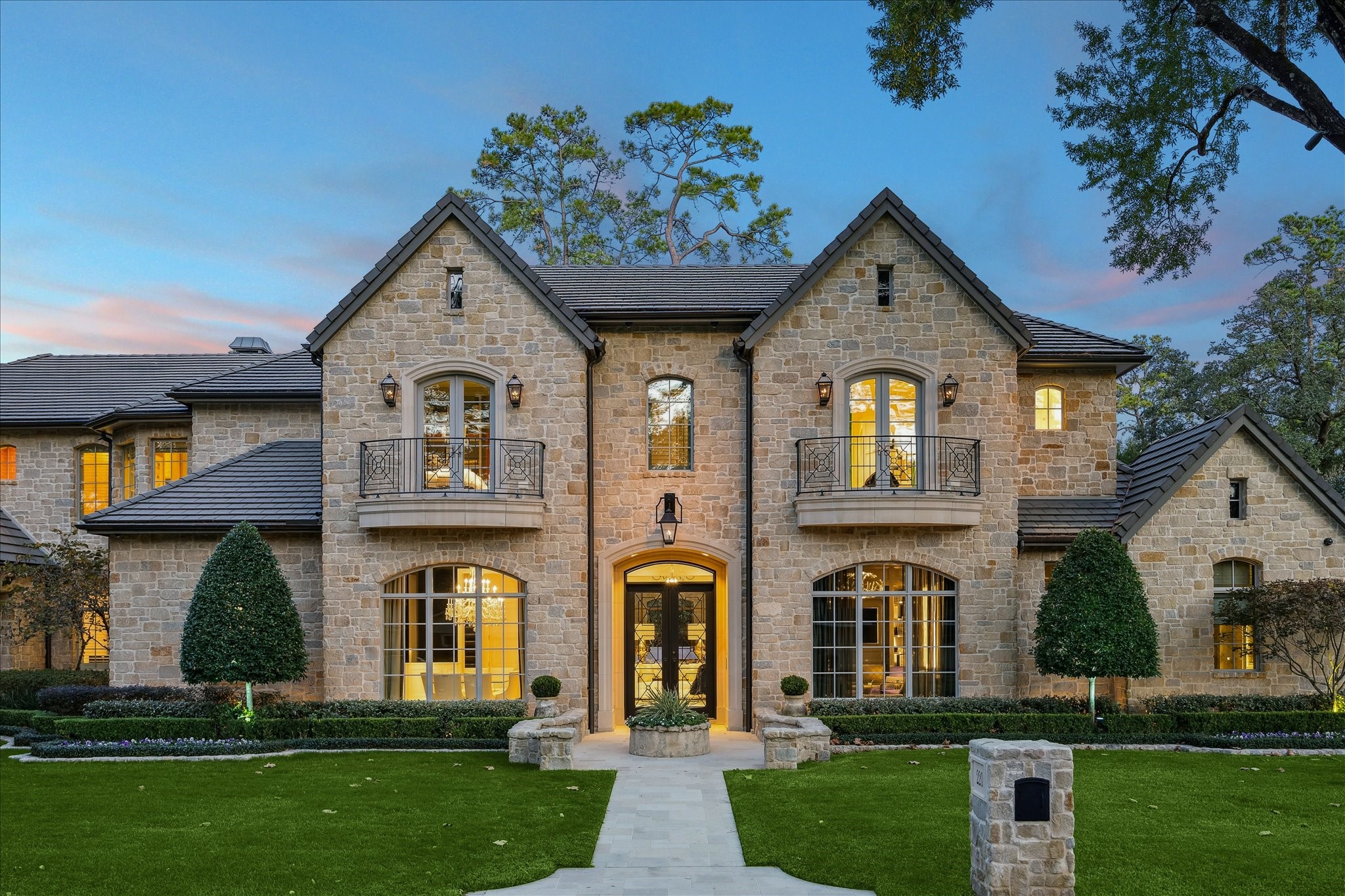 Welcome to 220 Merrie Way Lane. The home’s front elevation blends classic architecture with lush, curated landscaping—a collaboration between Kara Childress, Ken Newberry, Concord Builders, and Exterior Worlds, resulting in a beautifully cohesive design.