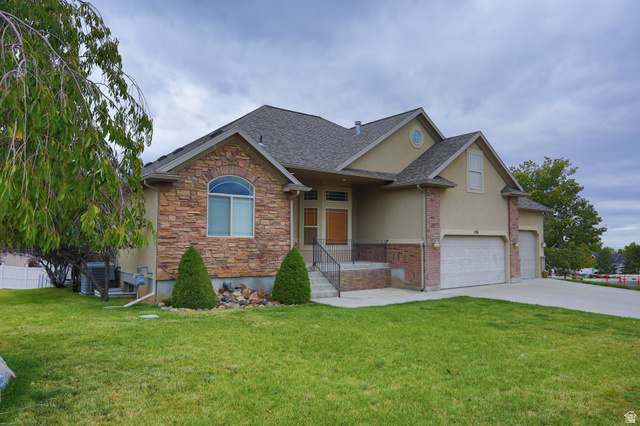 426 Deer Hollow Road Tooele, UT 84074 - Photo 27 of 37 View of front of home with a front yard, stucco siding, driveway, and a shingled roof