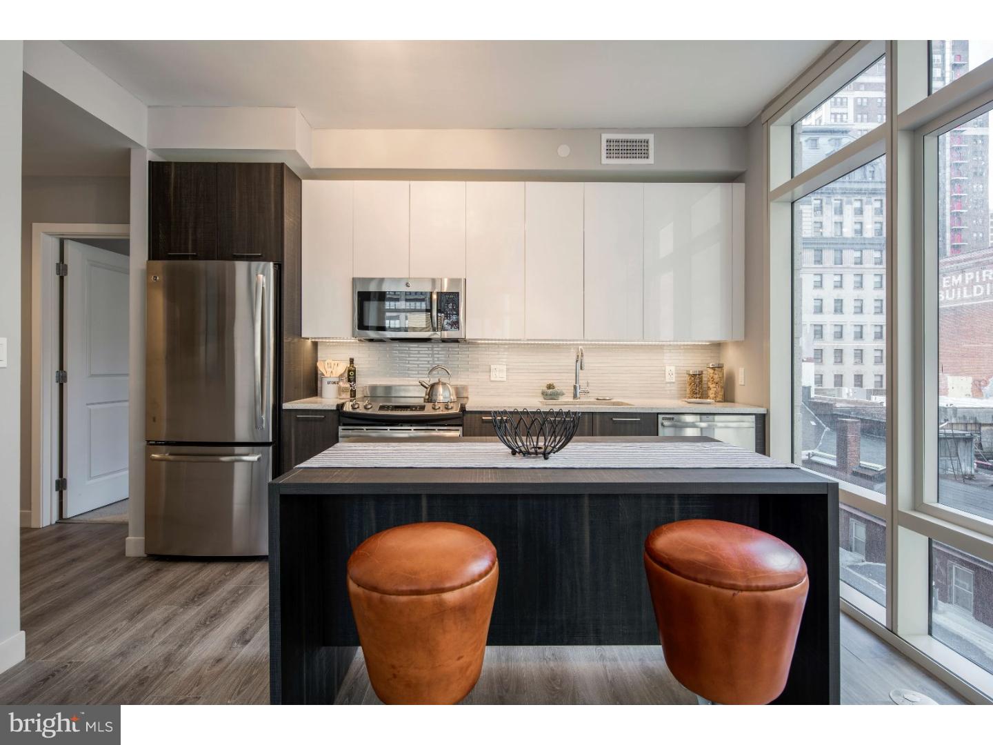 1213 Walnut Street, Unit 1B0301 Philadelphia, PA 19107 - Photo 2 of 10 a kitchen with stainless steel appliances a sink stove refrigerator and wooden floor
