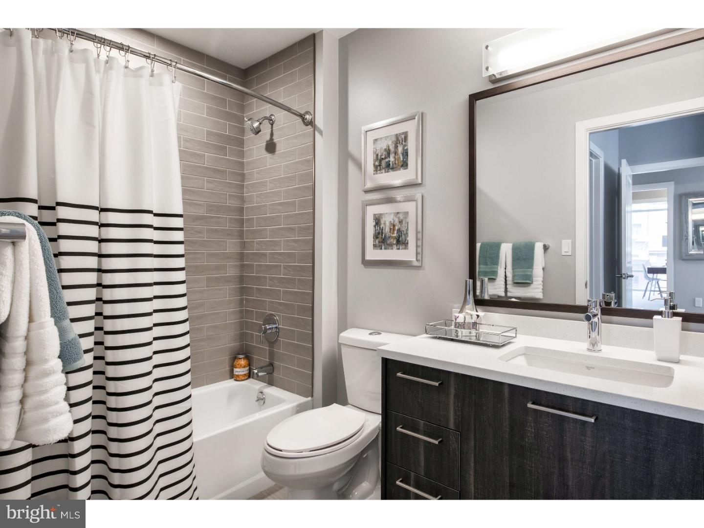 1213 Walnut Street, Unit 1B0301 Philadelphia, PA 19107 - Photo 7 of 10 a bathroom with a sink a toilet a mirror and shower curtain