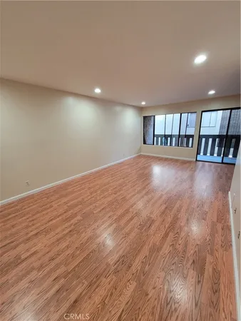 a view of empty room with wooden floor and staircase